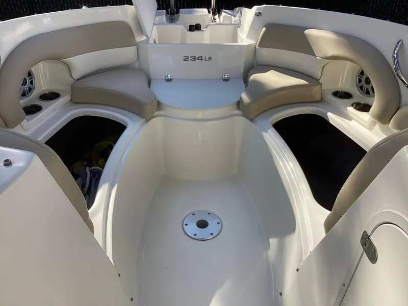 Slide: The Image of 2017 Stingray 234 LR boat interior with beige seating and cup holders. - 15