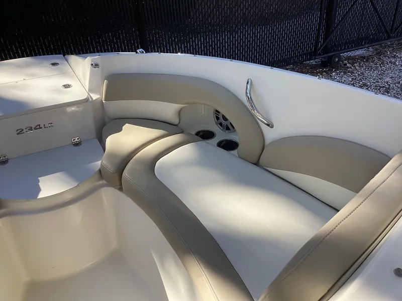 Slide: The Image of 2017 Stingray 234 LR boat interior with beige seating and cup holders. - 22