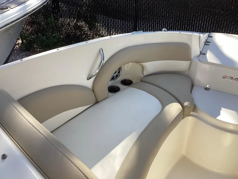 Slide: The Image of 2017 Stingray 234 LR boat interior with beige seating and cup holders. - 23