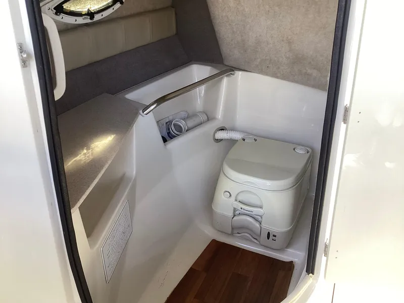 Slide: The Image of 2017 Stingray 234 LR boat interior with compact marine toilet. - 25
