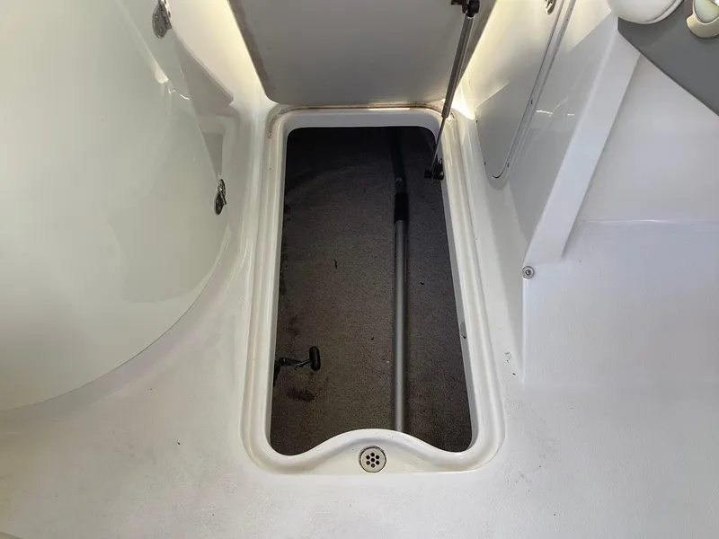 Slide: The Image of 2017 Stingray 234 LR boat storage compartment with open hatch. - 27