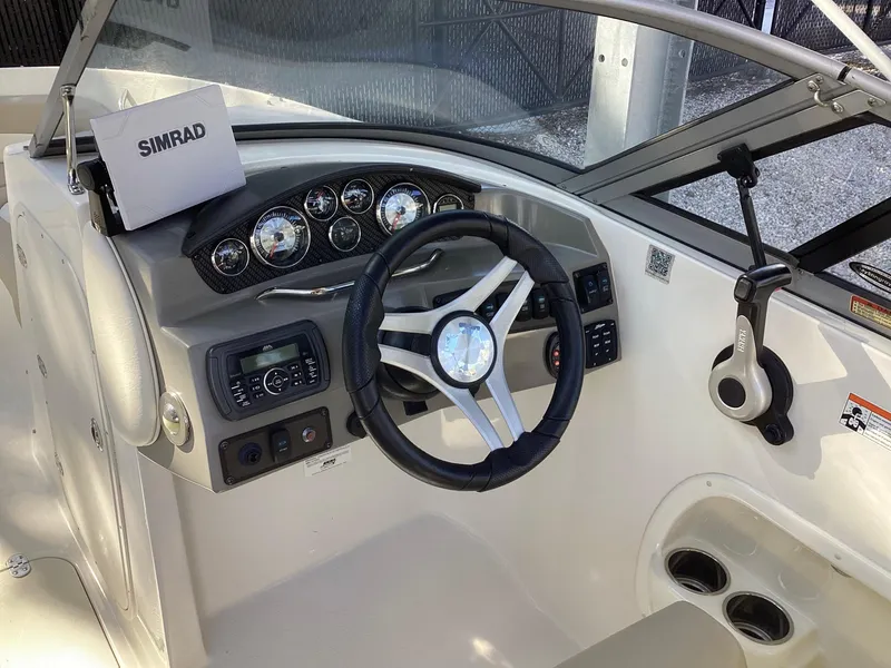 Slide: The Image of 2017 Stingray 234 LR boat dashboard with steering wheel and Simrad navigation system. - 29