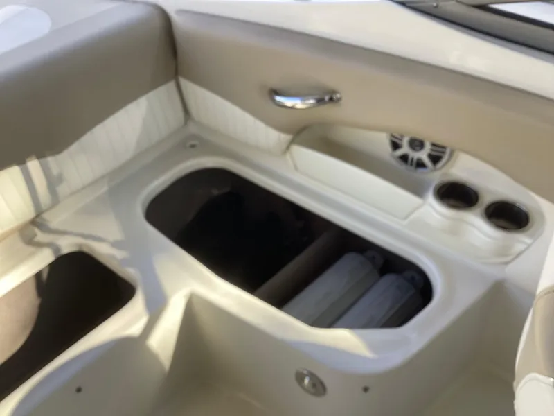 Slide: The Image of Interior of 2017 Stingray 234 LR boat with storage compartment and cup holders. - 32