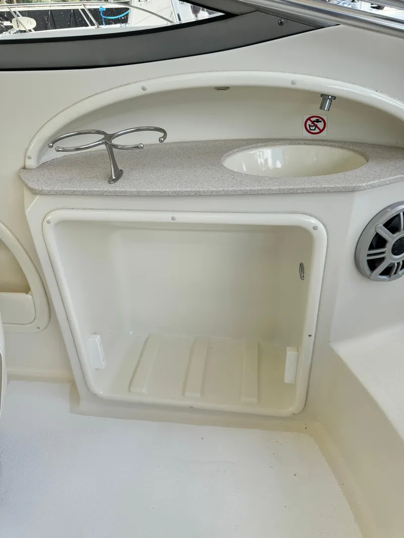 Slide: The Image of 2017 Stingray 234 LR boat interior with sink and storage compartment. - 33