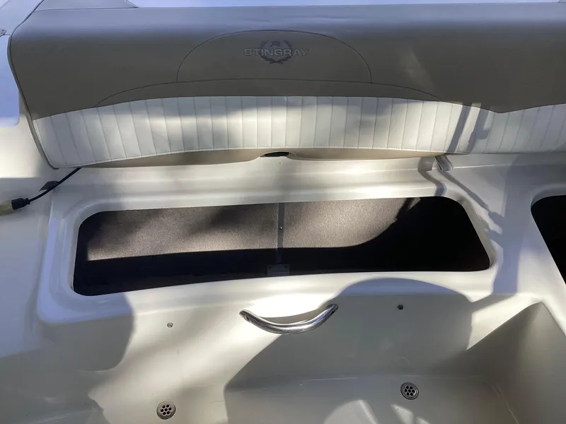 Slide: The Image of 2017 Stingray 234 LR boat interior storage compartment with cushioned seating. - 34