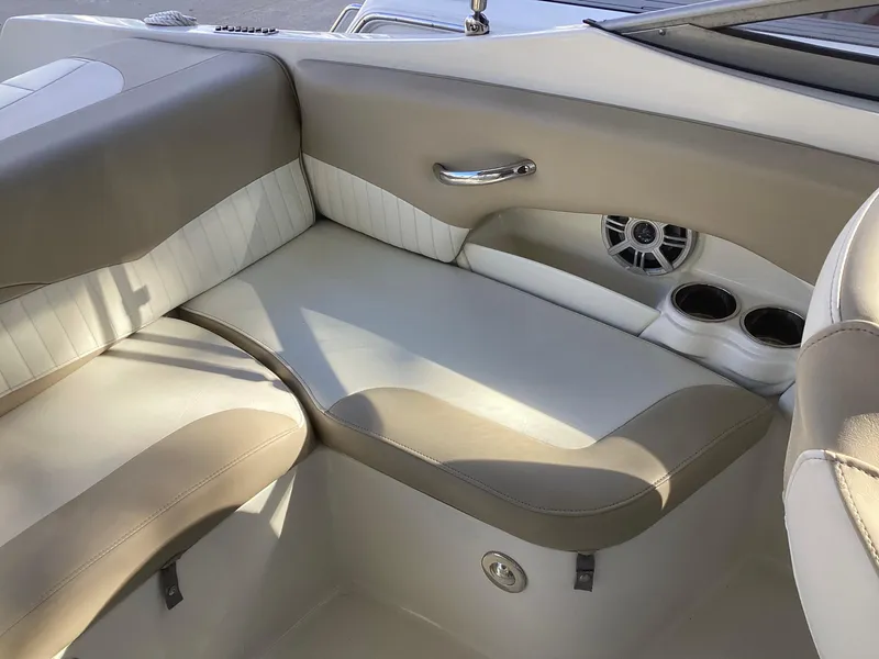 Slide: The Image of 2017 Stingray 234 LR boat interior with beige and white seating, cup holders, and speaker. - 39