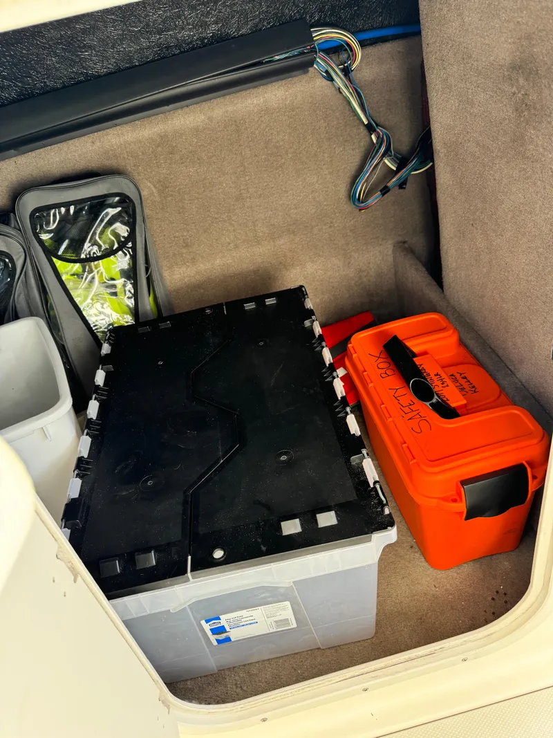 Slide: The Image of Storage compartment in a 2017 Stingray 234 LR boat with battery and safety equipment. - 44