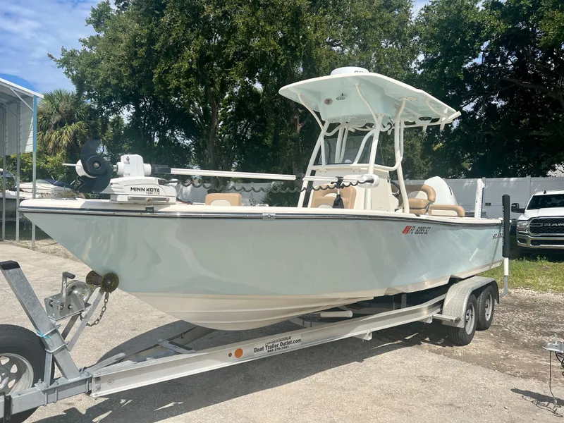 Slide: The Image of 2021 Sea Born LX24 boat on trailer with Minn Kota motor, parked outdoors. - 3