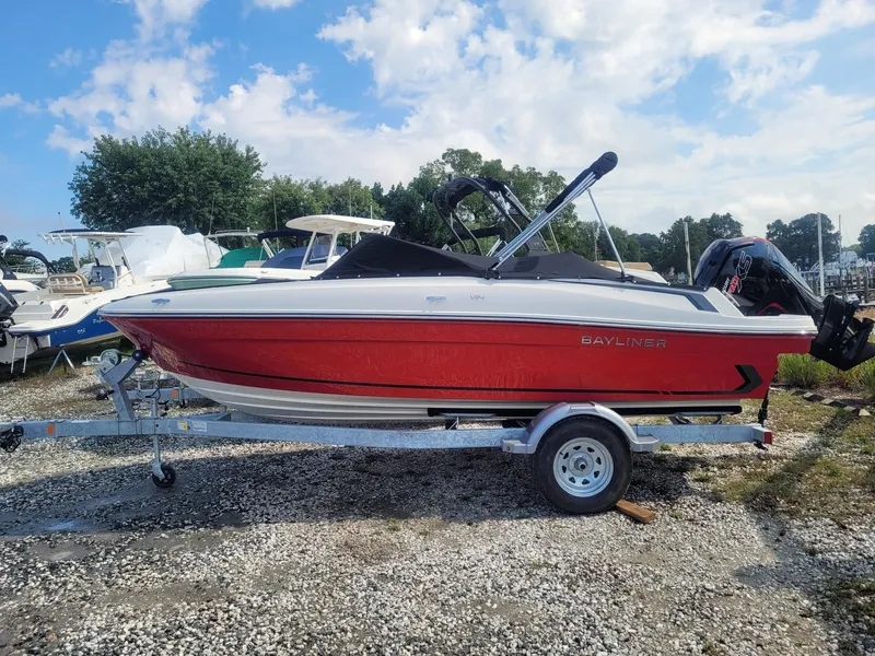 The Image of 2025 Bayliner VR4 Bowrider OB in red on trailer, parked outdoors. - 1