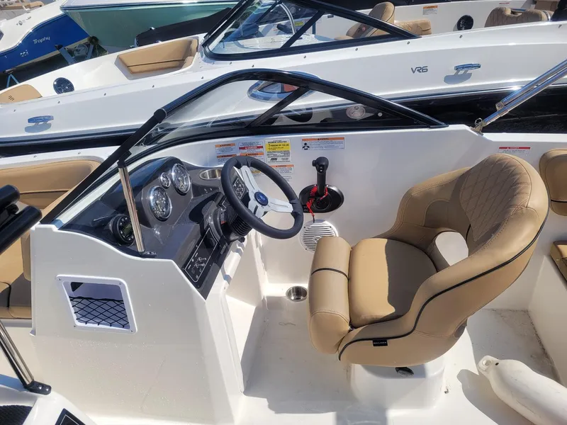 Slide: The Image of 2025 Bayliner VR4 Bowrider OB cockpit with steering wheel and beige seating. - 11