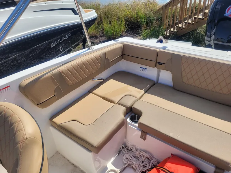 Slide: The Image of 2025 Bayliner VR4 Bowrider OB interior with tan seating and storage. - 7