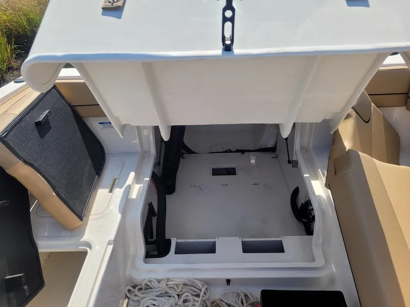 Slide: The Image of 2025 Bayliner VR4 Bowrider OB storage compartment with open hatch and visible rope. - 9