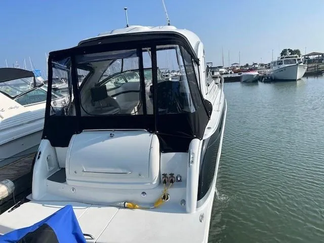Slide: The Image of 2011 Formula 34 PC boat docked at marina, rear view with black canopy. - 11