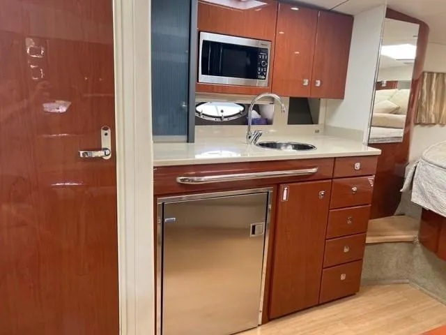 Slide: The Image of 2011 Formula 34 PC yacht interior kitchen with wood cabinetry, stainless appliances, and modern design. - 19