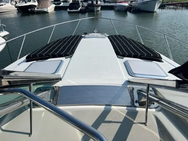 Slide: The Image of 2011 Formula 34 PC yacht bow view at marina, featuring sleek design and sun pads. - 22