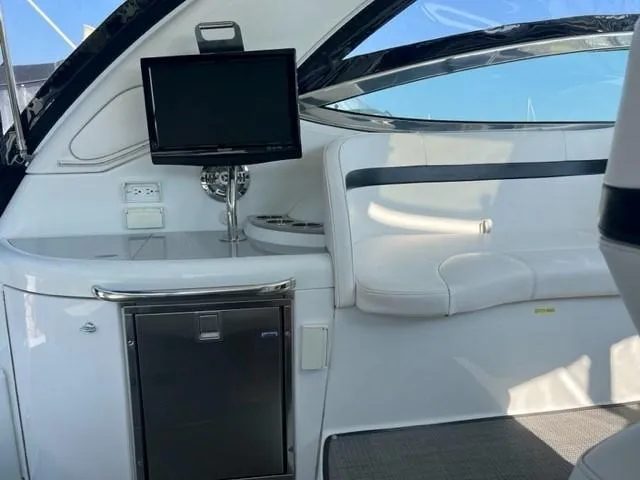 Slide: The Image of 2011 Formula 34 PC yacht interior with seating, TV, and mini-fridge. - 26