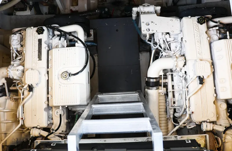 Slide: The Image of Engine room of a 2015 Prestige 520 yacht, featuring dual engines and a central ladder. - 12