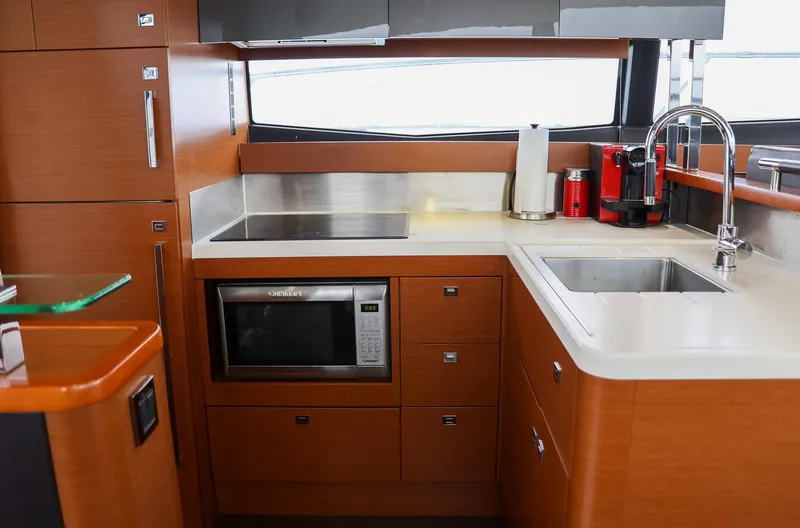 Slide: The Image of Modern kitchen in a 2015 Prestige 520 yacht with wood cabinetry and stainless steel appliances. - 13