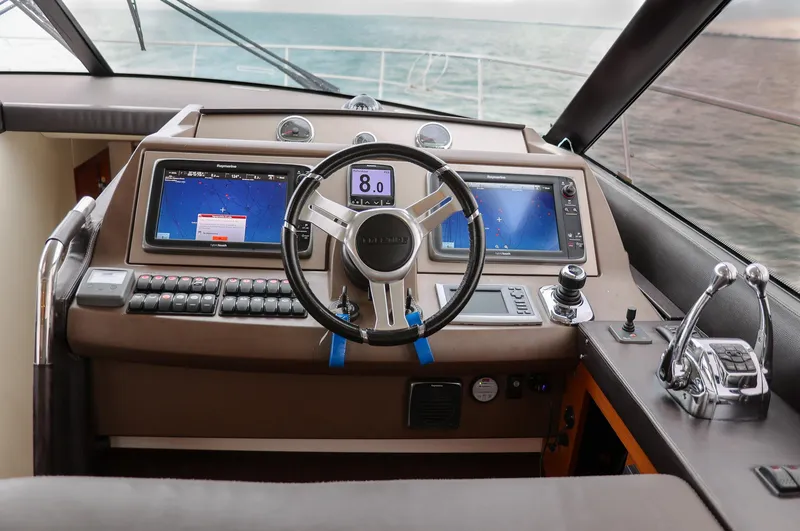 Slide: The Image of Cockpit of 2015 Prestige 520 yacht with modern navigation controls and ocean view. - 2