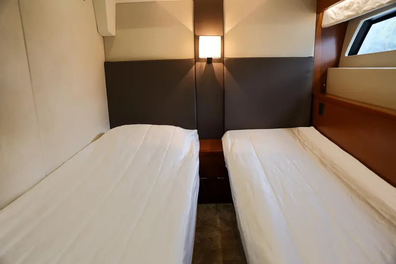 Slide: The Image of Twin beds in a 2015 Prestige 520 yacht cabin, featuring modern design and soft lighting. - 26