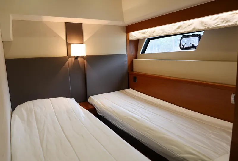 Slide: The Image of Twin cabin beds in a 2015 Prestige 520 yacht, featuring modern design and window view. - 27