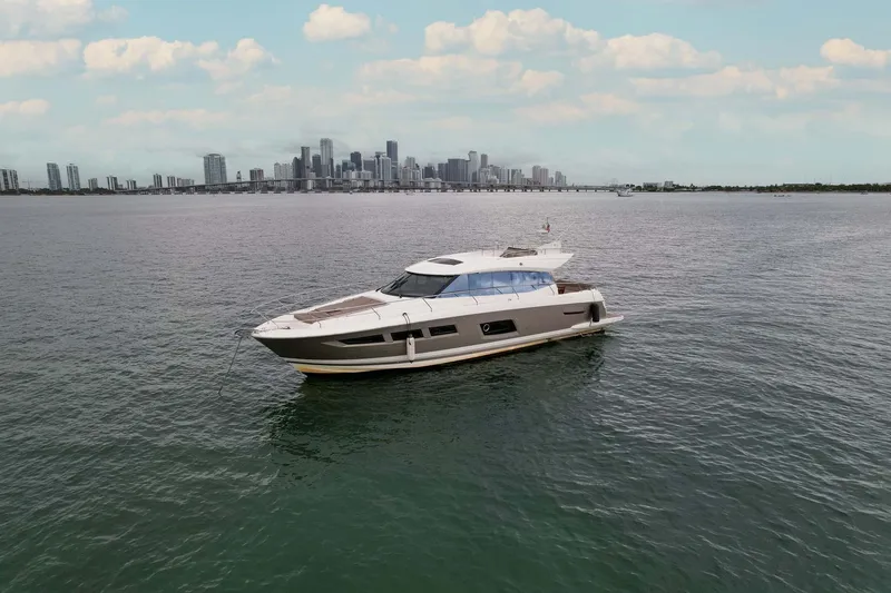 Slide: The Image of Prestige 520 yacht cruising on open water with city skyline in the background, 2015 model. - 29