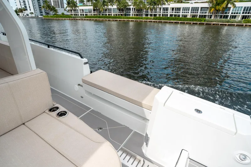 Slide: The Image of 2025 Quarken 35 Sport Tourer boat interior with beige seating, cup holders, and waterfront view. - 23