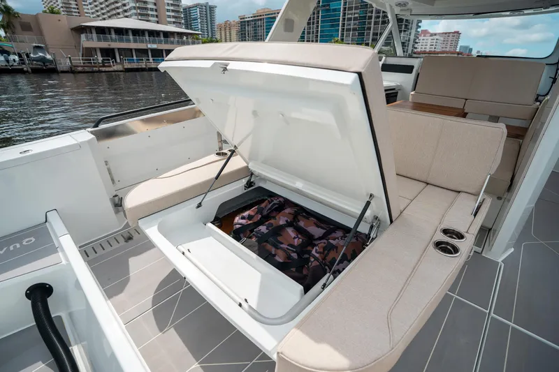 Slide: The Image of 2025 Quarken 35 Sport Tourer with open storage compartment, beige seating, and waterfront view. - 15