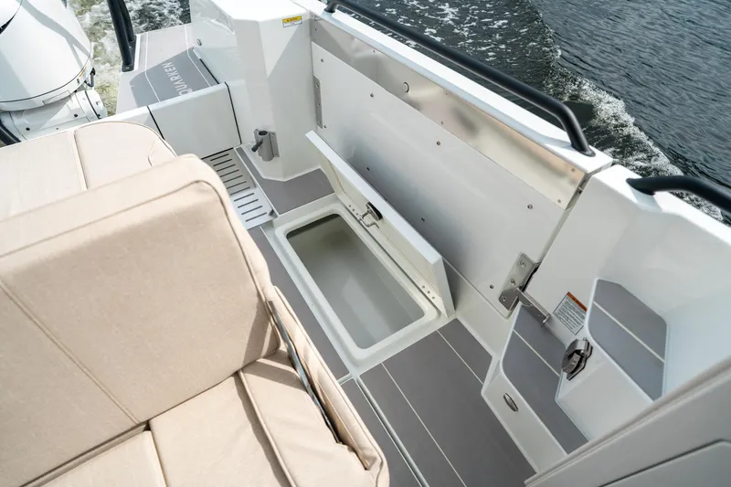 Slide: The Image of 2025 Quarken 35 Sport Tourer boat interior with open storage compartment and beige seating. - 20
