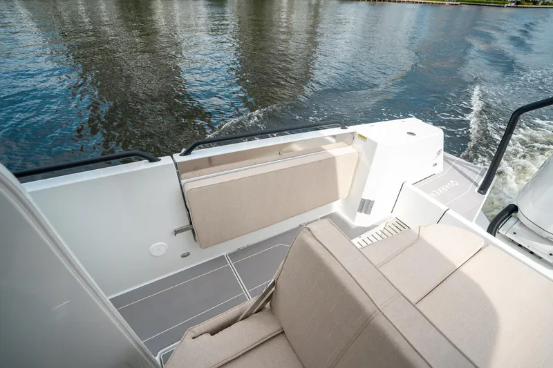 Slide: The Image of 2025 Quarken 35 Sport Tourer boat interior with beige seating, on calm water. - 24