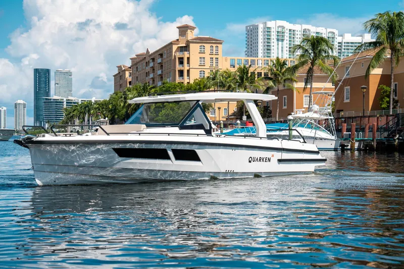 Slide: The Image of 2025 Quarken 35 Sport Tourer boat cruising in a sunny urban waterfront setting. - 4