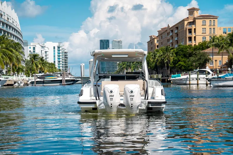 Slide: The Image of 2025 Quarken 35 Sport Tourer boat cruising in a scenic urban waterway. - 7