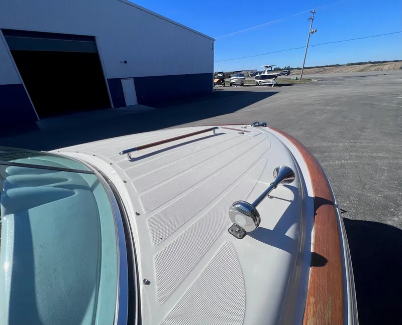 Slide: The Image of 2005 Chris-Craft Speedster boat with wooden accents, parked near a warehouse. - 11