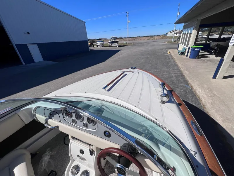 Slide: The Image of 2005 Chris-Craft Speedster boat parked near a marina, showcasing its elegant dashboard and design. - 12