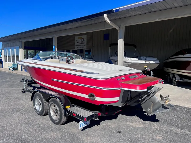 Slide: The Image of 2005 Chris-Craft Speedster boat on trailer, red and white, parked outdoors. - 3