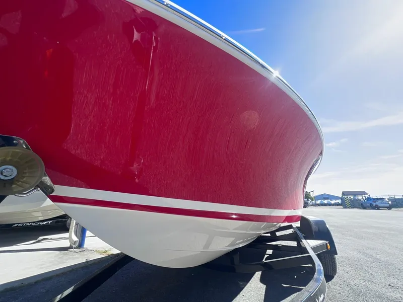 Slide: The Image of 2005 Chris-Craft Speedster boat with red hull on trailer under clear blue sky. - 9