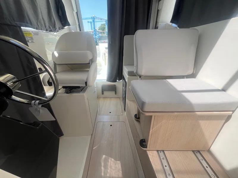 Slide: The Image of 2025 Bayliner Trophy T25 Pilothouse interior with modern seating and steering wheel. - 10