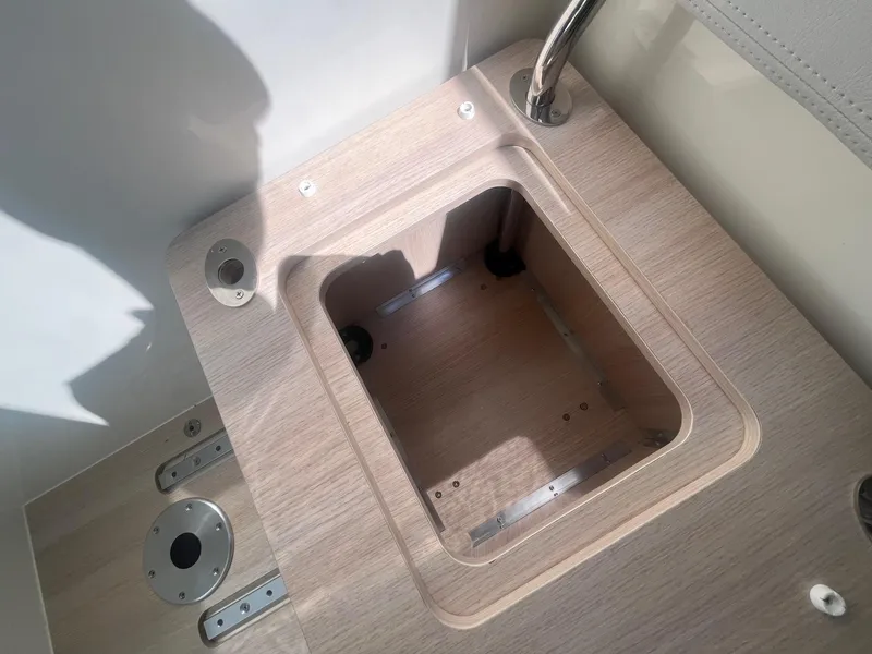 Slide: The Image of 2025 Bayliner Trophy T25 Pilothouse interior detail with wooden compartment and metal fixtures. - 13