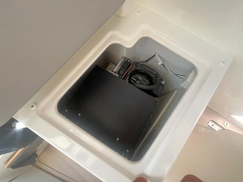 Slide: The Image of 2025 Bayliner Trophy T25 Pilothouse storage compartment with electrical components. - 15