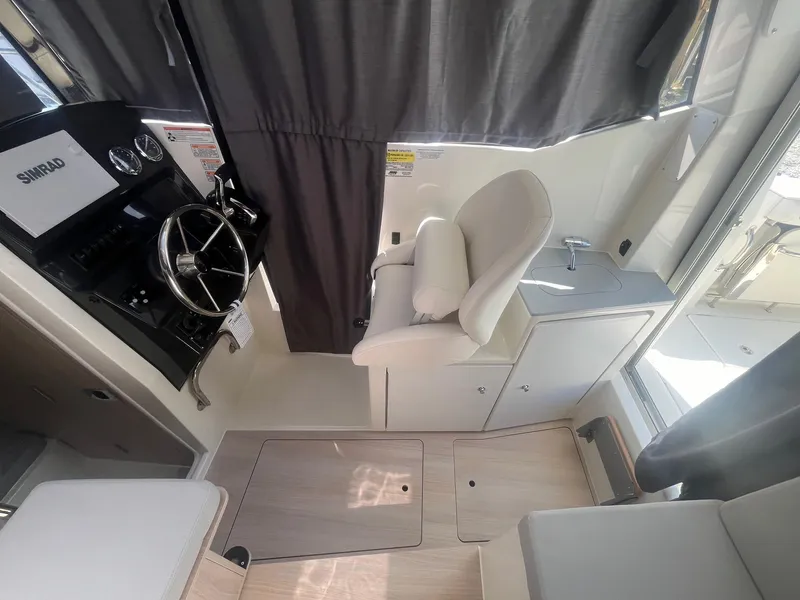 Slide: The Image of 2025 Bayliner Trophy T25 Pilothouse interior with steering wheel and seating. - 18