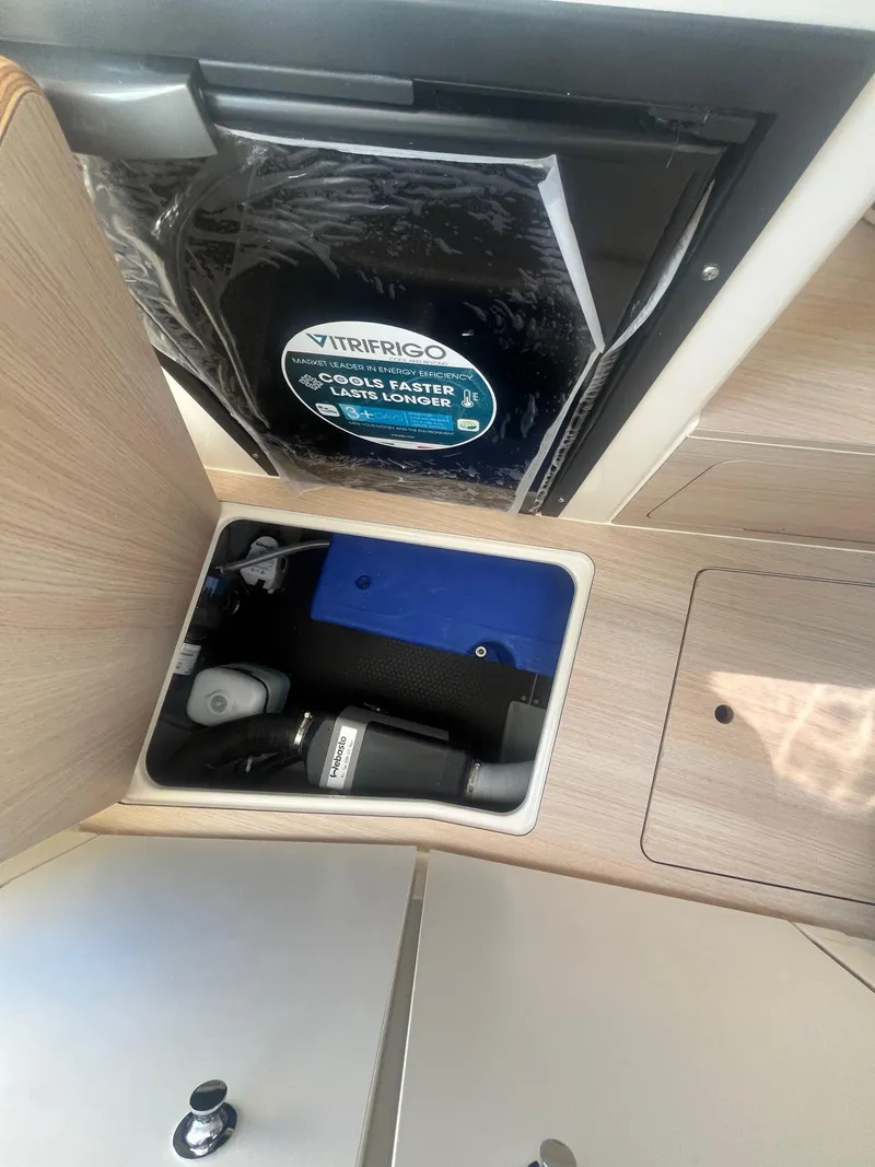 Slide: The Image of 2025 Bayliner Trophy T25 Pilothouse interior with storage and mini fridge. - 21