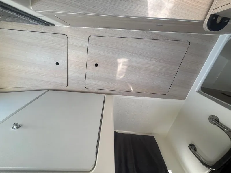 Slide: The Image of Interior of 2025 Bayliner Trophy T25 Pilothouse, featuring sleek cabinetry and modern design. - 22