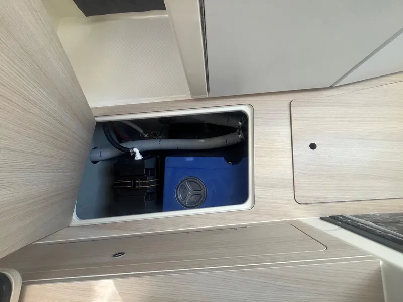Slide: The Image of 2025 Bayliner Trophy T25 Pilothouse interior storage compartment with blue container. - 23