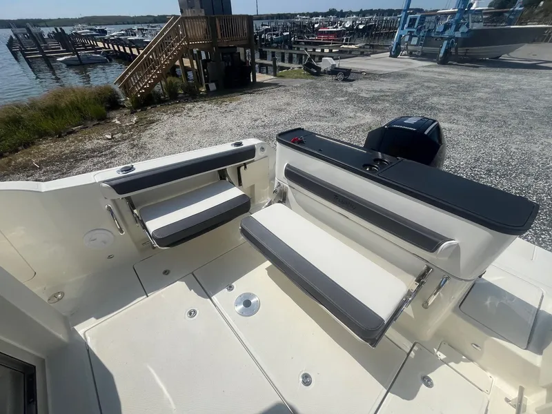 Slide: The Image of 2025 Bayliner Trophy T25 Pilothouse boat interior with foldable seating and waterfront view. - 27