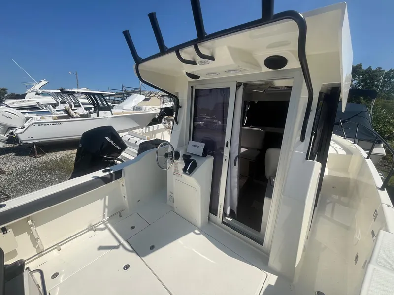 Slide: The Image of 2025 Bayliner Trophy T25 Pilothouse boat interior with steering console and sliding door. - 28