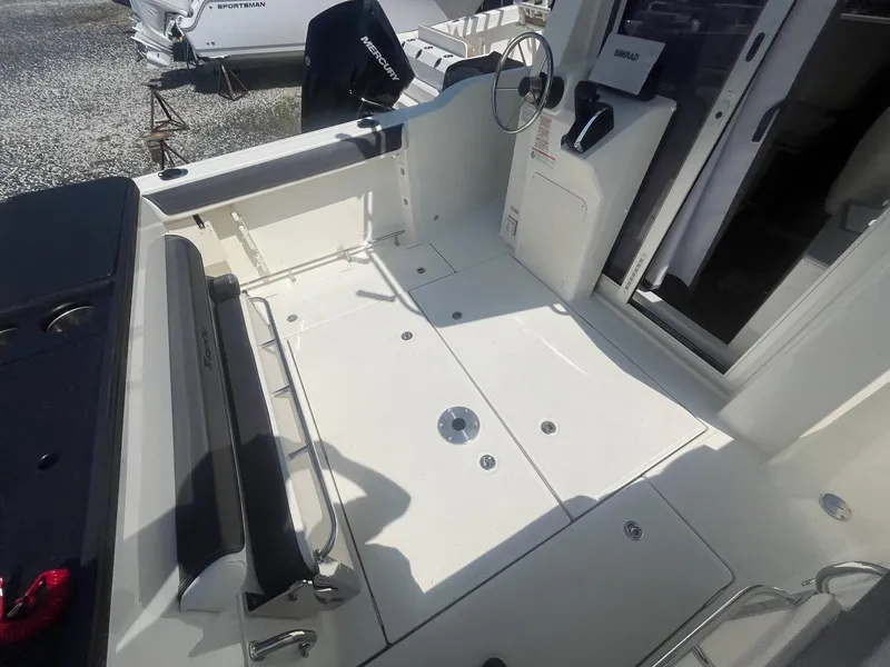 Slide: The Image of 2025 Bayliner Trophy T25 Pilothouse boat interior with seating and steering wheel. - 29