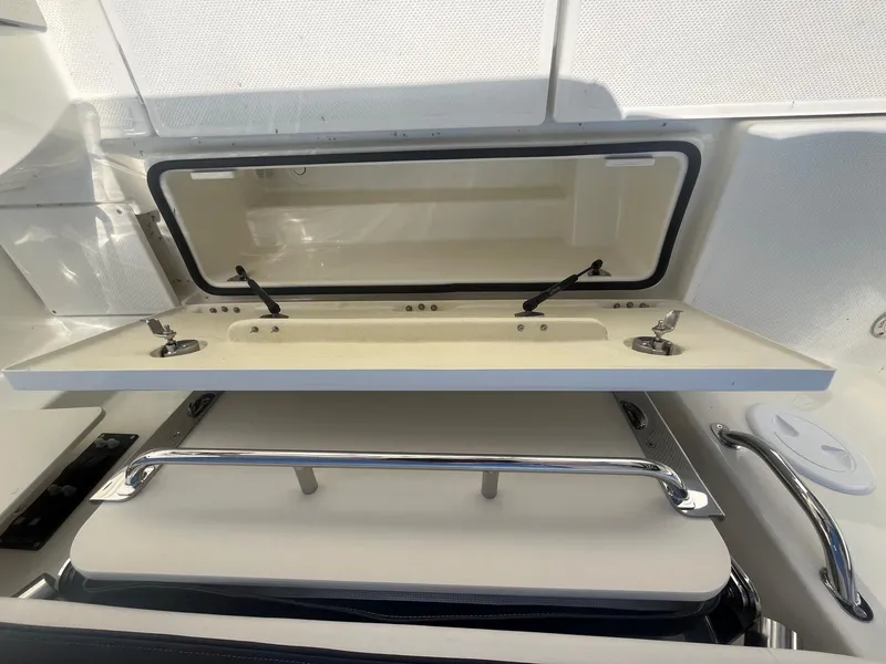 Slide: The Image of 2025 Bayliner Trophy T25 Pilothouse storage compartment with open hatch and stainless steel rail. - 33