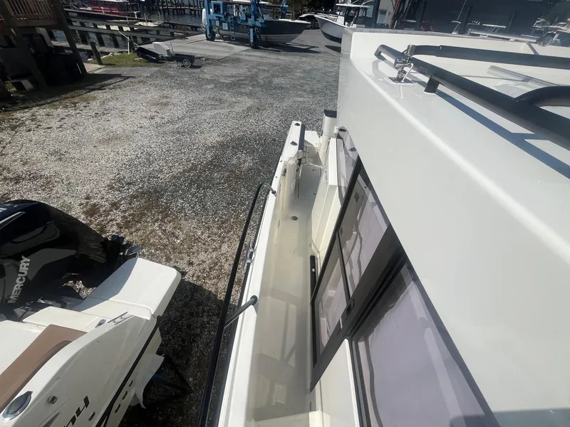 Slide: The Image of 2025 Bayliner Trophy T25 Pilothouse boat docked, side view with Mercury engine. - 42