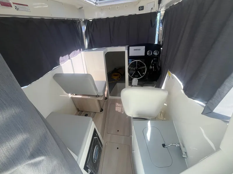 Slide: The Image of 2025 Bayliner Trophy T25 Pilothouse interior with helm, seating, and modern amenities. - 6
