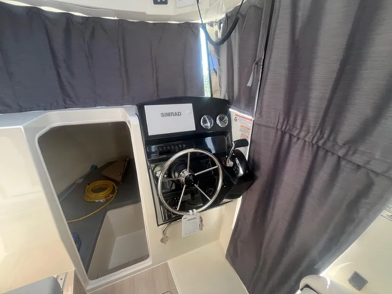 Slide: The Image of 2025 Bayliner Trophy T25 Pilothouse helm with steering wheel and navigation equipment. - 7